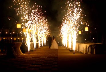 Newly married couple walking together between lines of sparkling wedding fireworks