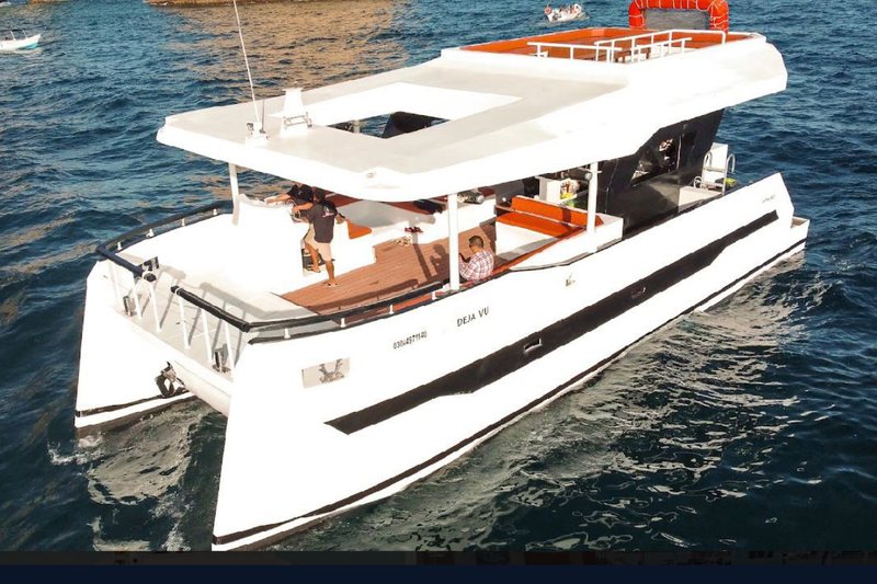60 foot event catamaran in red and white built for large group events in Cabo