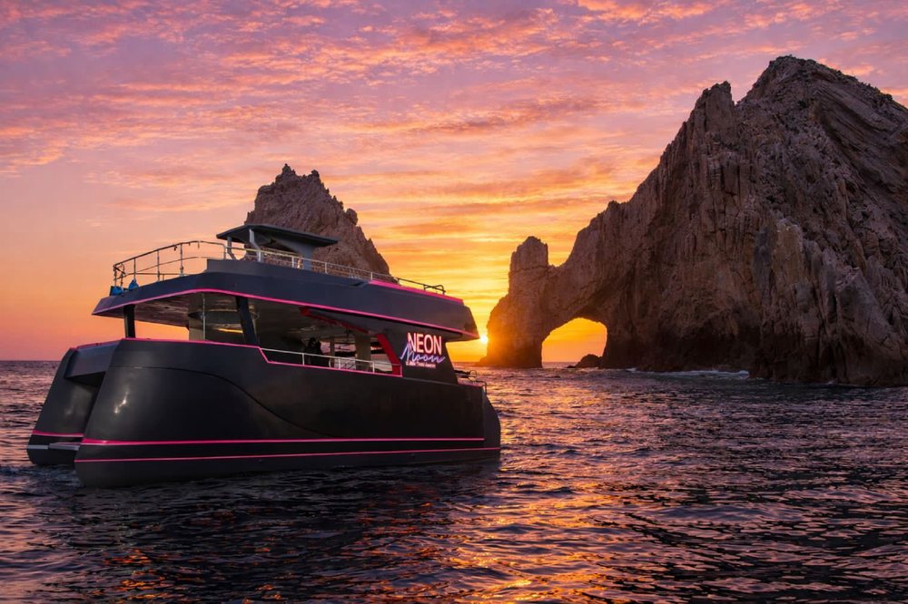 Catamaran at sunset near the Arch of Cabo San Lucas on the Sea of Cortez