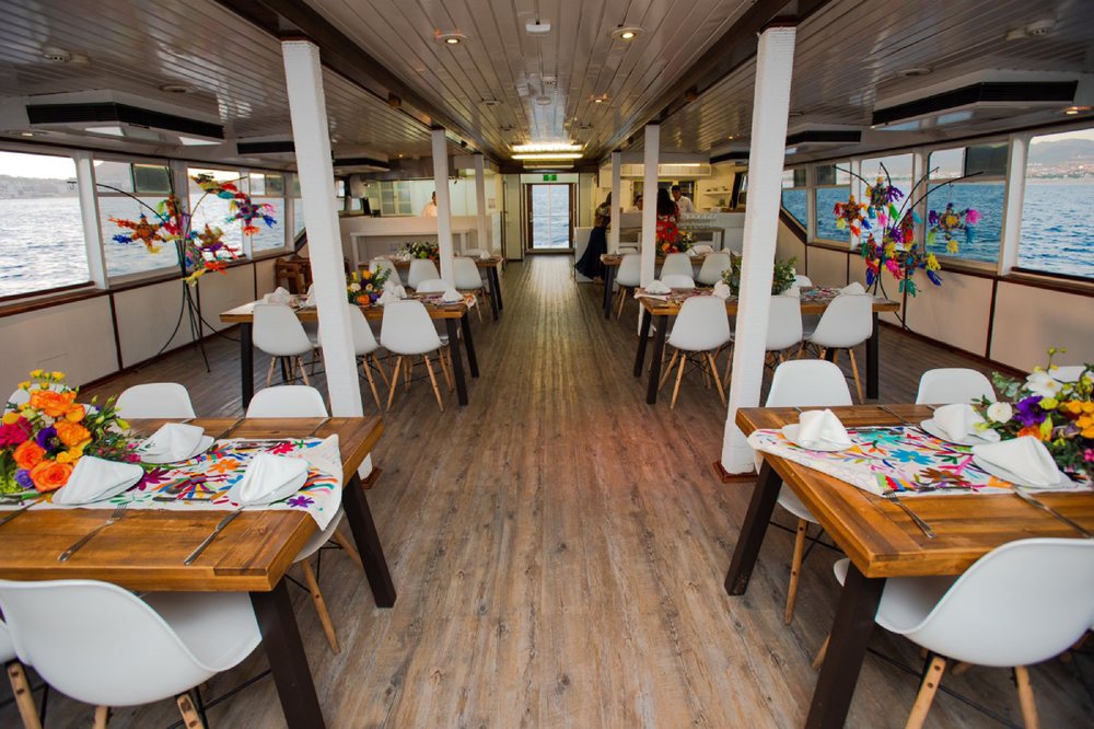 Wedding reception setup inside a spacious event boat with elegant table styling